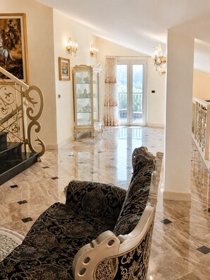 A spacious living area with a marble floor, a grand staircase, and a large window offering a view of the outdoors. - Villa on the Lido of Venice, for those seeking luxury, convenience close Venice. (Venezia)