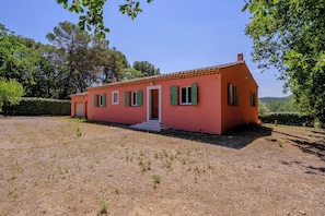 A single-story house with a red facade, green shutters, and a small porch. - Maison Vigneron | Domaine Tour Campanets (Le Puy-Sainte-Réparade)