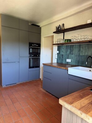 A kitchen with grey cabinets, a built-in oven, a wooden countertop, and a tiled backsplash. - Gorgeous 3-bedroom house with AC in Cabrières-d'Aigues (Cabrières-d'Aigues)