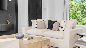 A modern living room with a sofa, a coffee table, and a fireplace. - NEW Home with Luxury Wet Room & Rooftop Hot Tub 8 to Broadway (Nashville)