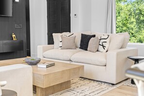 Ein stilvolles Wohnzimmer mit einer Couch, einem Couchtisch und einem Kamin.