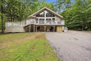 A two-story building with a balcony and a covered porch area. - Family Cabin Near Story Land & Attitash (Bartlett)