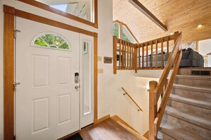 A staircase with wooden railings leading to a living area with a sofa. - Family Cabin Near Story Land & Attitash (Bartlett)