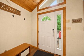 A wooden door with a window, a welcome sign, a bench, and a keys sign. - Family Cabin Near Story Land & Attitash (Bartlett)