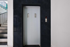 A closed elevator door with a digital display and a keypad on the wall. - Classic Golden Retreat Hotel (Anand)