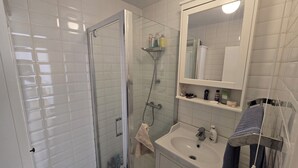 A bathroom with a glass-enclosed shower, a sink, and a mirror above the mirror cabinet. - Bright and spacious 1 bedroom flat near Warren Street. Perfect to explore London (London)