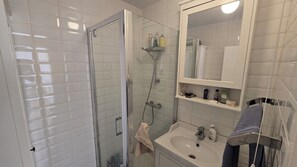 A bathroom with a glass-enclosed shower, a sink, and a mirror above the mirror cabinet. - Bright and spacious 1 bedroom flat near Warren Street. Perfect to explore London (London)