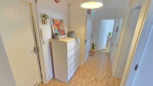 A hallway with a white wardrobe, a painting, and a potted plant. - Bright and spacious 1 bedroom flat near Warren Street. Perfect to explore London (London)