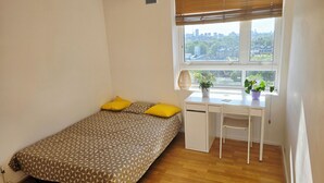 A bedroom with a bed, a desk, and a window with a city view. - Bright and spacious 1 bedroom flat near Warren Street. Perfect to explore London (London)