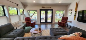 A spacious living area with two leather armchairs, a sofa, and a coffee table. - Waterfront Lake House Retreat — Sleeps 12 _ Private Dock _ Upgraded Interior (Brownwood)