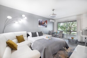 A modern hotel room with a bed, a sofa, a desk, and a dining area. - Bright One Bedroom Apartment in Cannes - 2394 (Cannes)