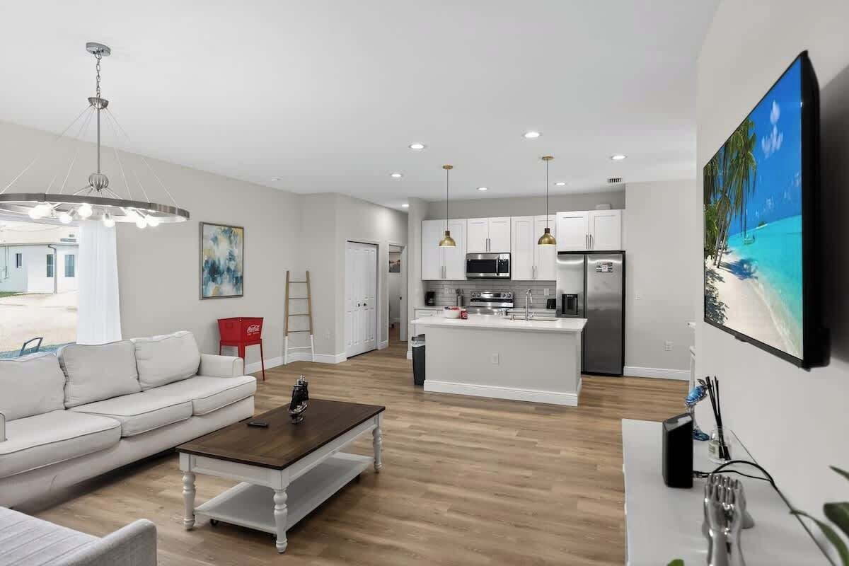 A modern living room with a sofa, coffee table, and a TV mounted on the wall.