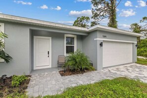 A residential house with a garage, a front door, and a small porch area.