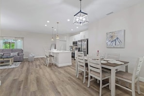 A modern kitchen with white cabinets, a central island, and stainless steel appliances.