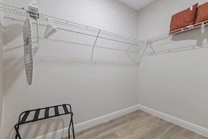 A room with a metal wire shelf, a black metal rack, and a white wall. - Comfortable 4BR Home for Groups (Port Charlotte)