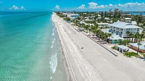 Ein Küstenhotel mit Blick auf den Strand, mehrstöckigen Gebäuden und einem Sandstrand.
