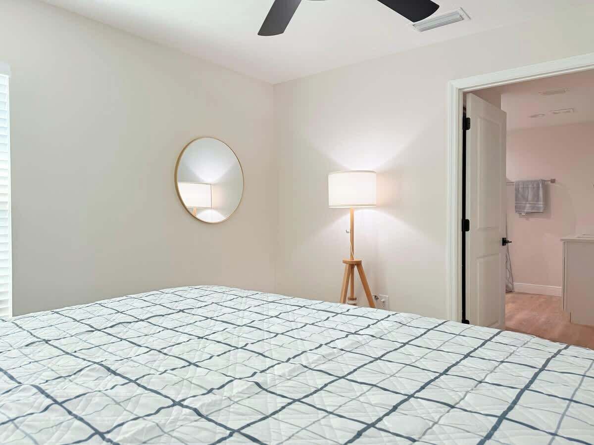 Een slaapkamer met een bed, een bedlampje en een deur naar een badkamer.