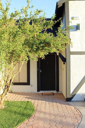 A house with a black door, a small garden, and a number 4877 on the wall. - Cozy 3-Bedroom Apartment | 15 Minutes from The Strip (Las Vegas)