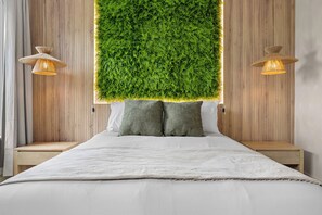 Ein Schlafzimmer mit einem Bett, zwei Nachttischen, einer an der Wand befestigten Zimmerpflanze und zwei Wandlampen.