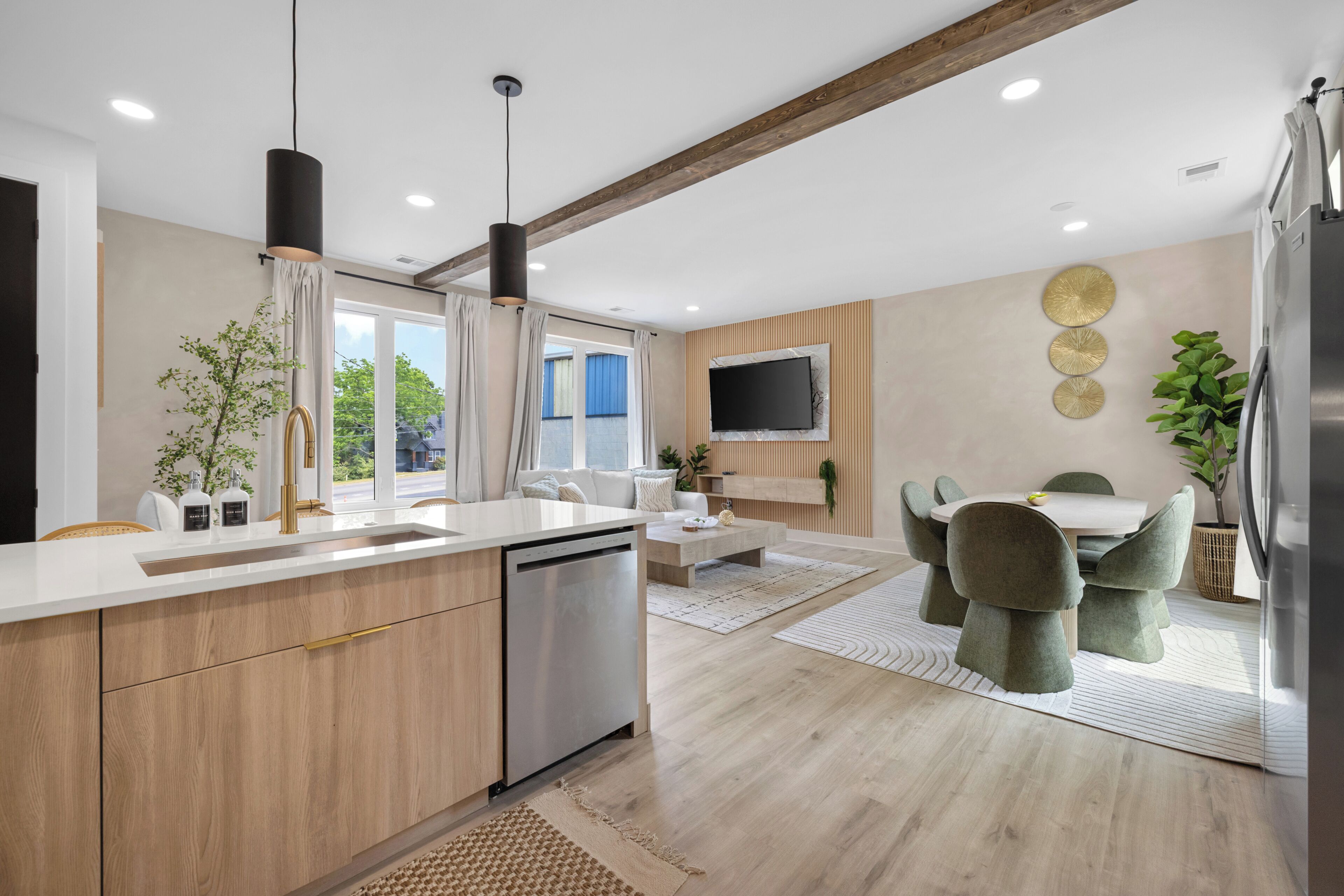 A modern kitchen with a built-in dishwasher, wooden cabinets, and a dining area with a table and chairs.