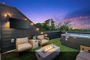 An outdoor patio with a fire pit, seating, and a hot tub. - Brand New Relaxing Luxury Home w/Rooftop Hot tub 7 to Broadway (Nashville)