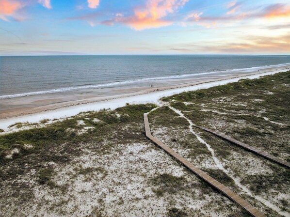 A beach with a wooden boardwalk leading to the shore, sandy dunes, and a calm sea under a partly cloudy sky. - Private Hot Tub | Dogs Welcome | Grill (Port St. Joe)