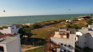 Zona residencial costera con casas, una playa y personas practicando kitesurf.
