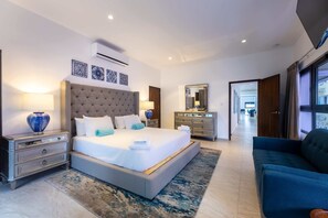 Une chambre d’hôtel moderne avec un grand lit, des tables de chevet, une commode et un miroir.