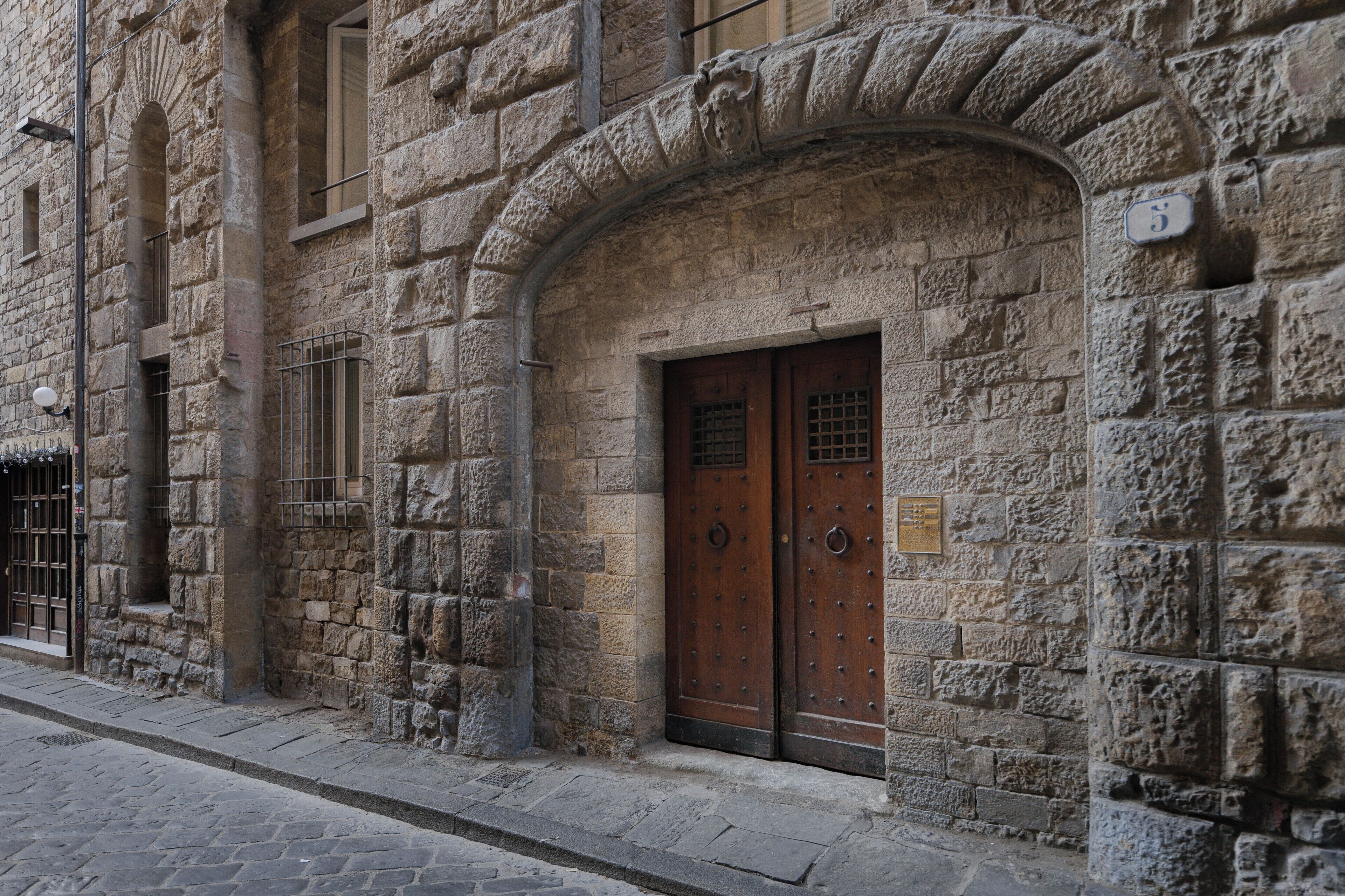 A stone building with a wooden door and a small plaque.