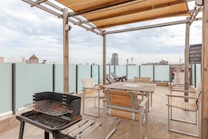 A rooftop terrace with a grill, seating, and a view of the cityscape. - Intimate rooftop terrace with a hot tub and 360° views of Barcelona (Barcelona)