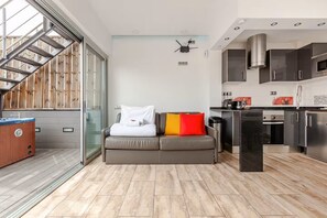 A modern living space with a sofa, a coffee machine, and a kitchen area. - Intimate rooftop terrace with a hot tub and 360° views of Barcelona (Barcelona)