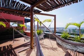 A rooftop terrace with a wooden pergola, a hammock, and potted plants. - Luxury loft in the heart of Playa del Carmen Stunning Rooftop Pool and Jacuzzi (Playa del Carmen)