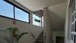A staircase leading to an upper floor, a fire extinguisher, and a potted plant. - Hotel Frailes (Arriaga)