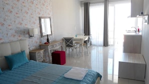 Una habitación de hotel con cama, escritorio, silla y un baño.