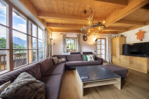 Ein gemütliches Wohnzimmer mit einem Ecksofa, einem Couchtisch und einem Fernseher.
