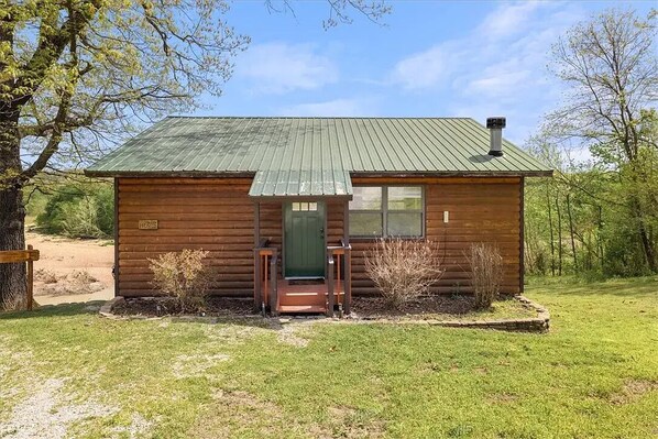A small log cabin with a metal roof, a front door, and a window. - Riverfront Blue Heron Cabin on the Kings River (Berryville)