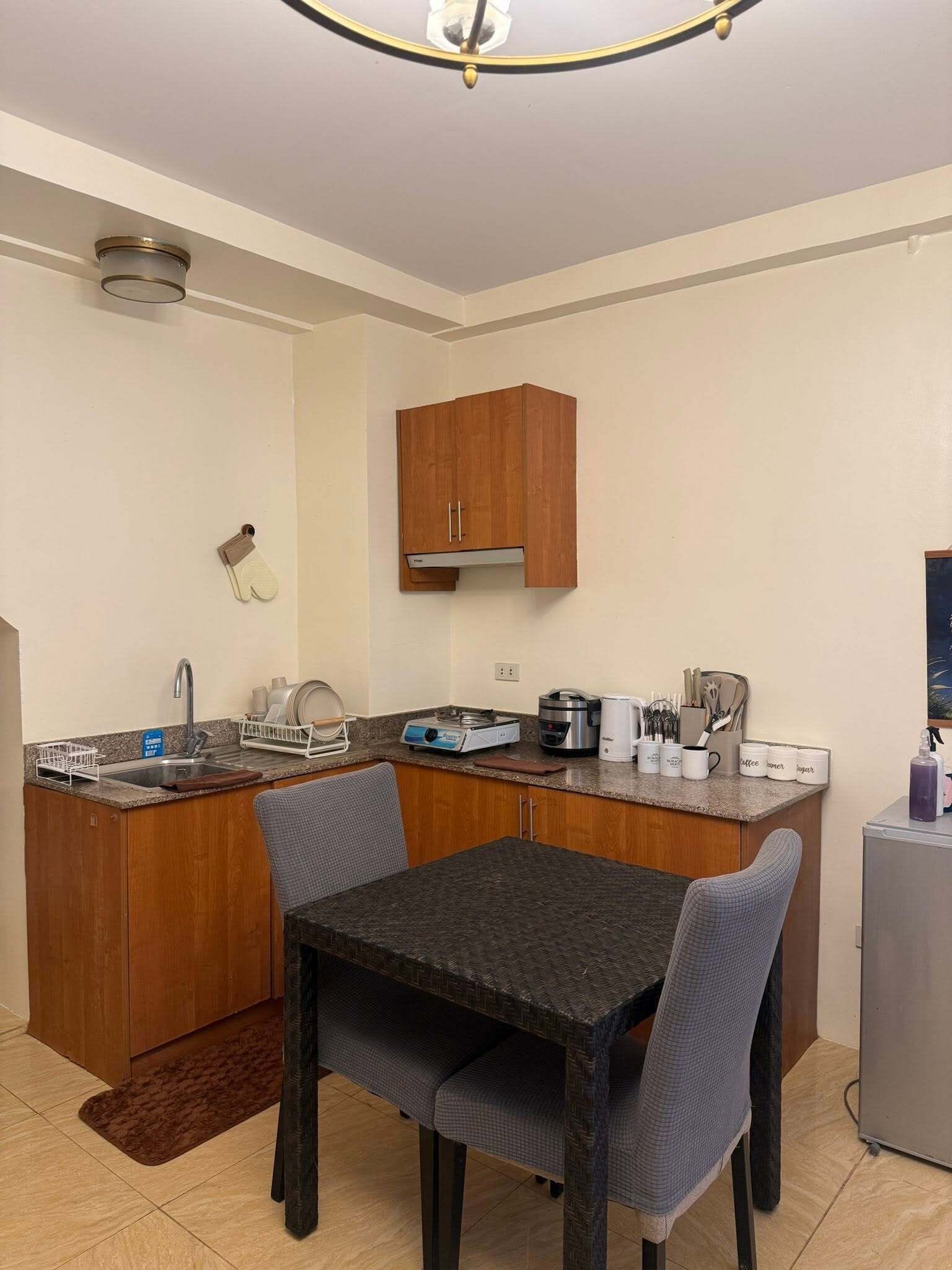 A compact kitchen with a dining area, equipped with a sink, stove, and various appliances.