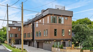 Ein modernes Wohngebäude mit zwei Etagen, flachem Dach, großen Fenstern und einem sichtbaren Garageneingang.