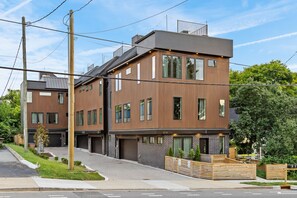 Ein modernes Wohngebäude mit zwei Etagen, flachem Dach, großen Fenstern und einem sichtbaren Garageneingang.