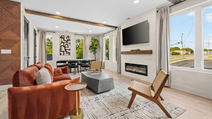 Ein modernes Wohnzimmer mit einer Couch, einem Couchtisch und einem Kamin.