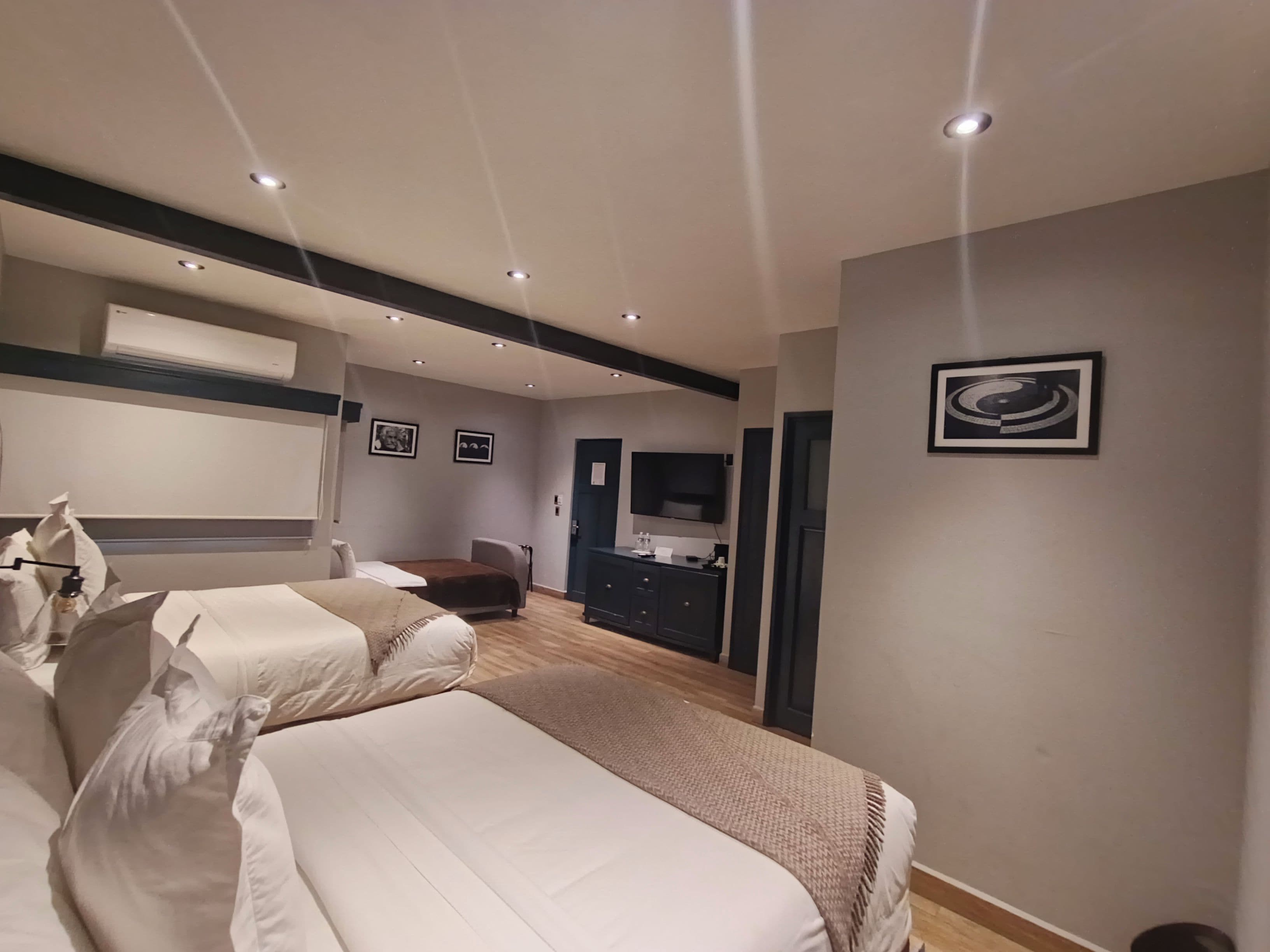 Un dormitorio moderno con una cama grande, un televisor y un escritorio con una silla.