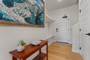 A hallway with a wooden bench, a white bowl, and a map of Keystone, Colorado. - Modern 3br Condo in Keystone (Keystone)
