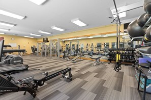 Un gimnàs amb cintes de córrer, aparells de musculació i peses lliures.