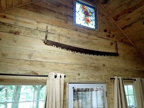 A wooden interior with a window, curtains, and a stained glass window. - Tiny Cabin with Fire Pit & Covered Porch Retreat in Salem, Missouri (Salem)