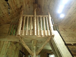 A rustic wooden ceiling with exposed beams and a central wooden structure. - Tiny Cabin with Fire Pit & Covered Porch Retreat in Salem, Missouri (Salem)