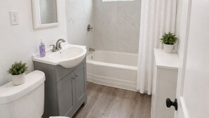 A bathroom with a toilet, sink, and bathtub.