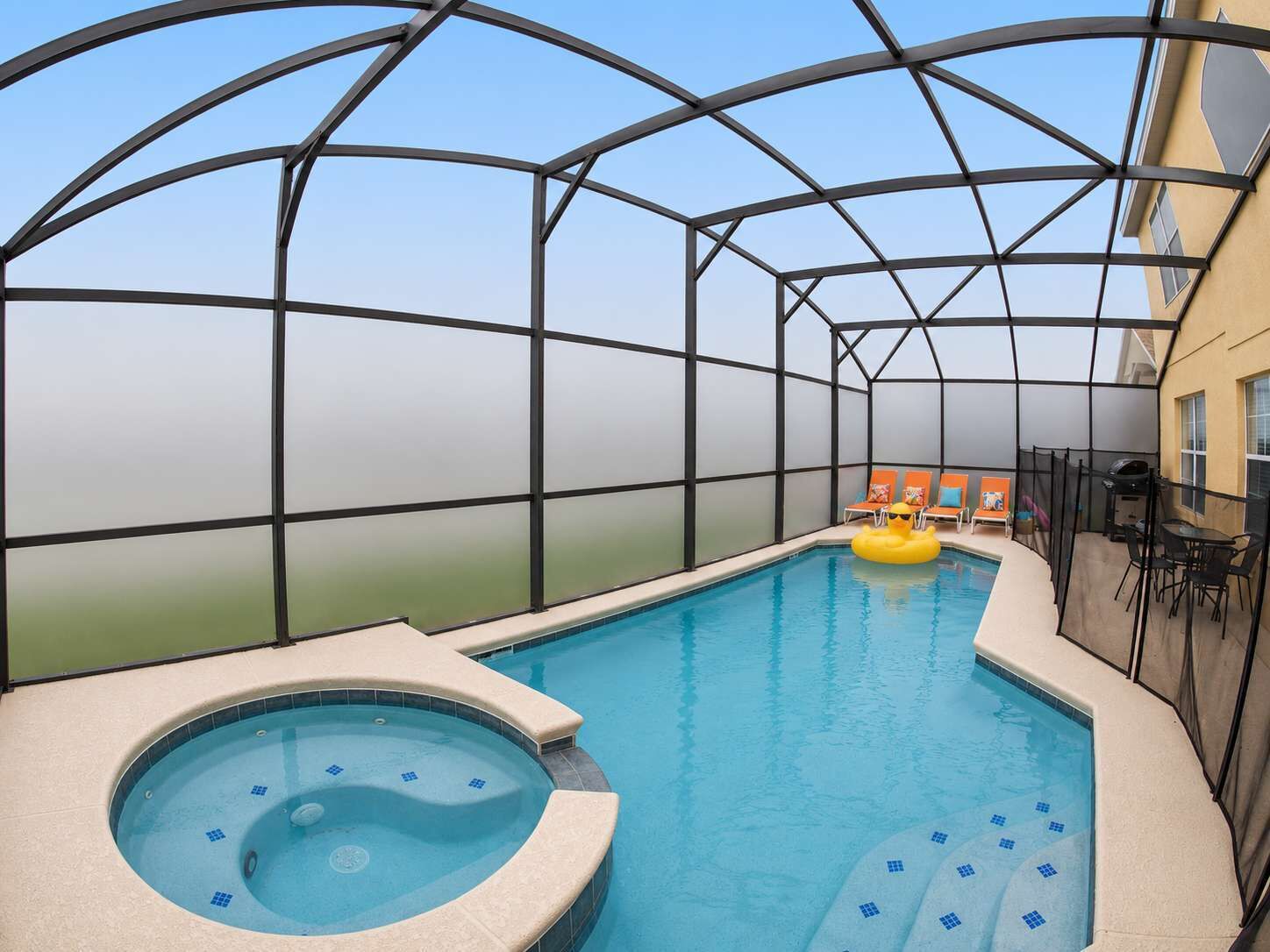 Une piscine intérieure dotée d’un jacuzzi, de chaises longues et d’un patio couvert.