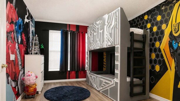 A room with a bunk bed, a desk, a window with curtains, and a wall with a geometric pattern. - 5BR Fantastic Villa  Pool & Game Room Near Disney (Kissimmee)