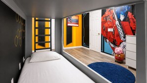A modern bedroom with a bed, a blue rug, a door, and a wall with a geometric pattern. - 5BR Fantastic Villa  Pool & Game Room Near Disney (Kissimmee)