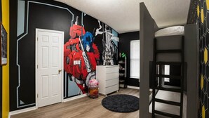 A room with a bunk bed, a white dresser, a wall mural, and a window with blinds. - 5BR Fantastic Villa  Pool & Game Room Near Disney (Kissimmee)